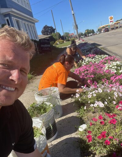 Image of filer credit union employees planting flowers to help community.